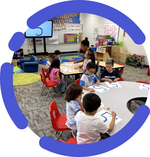 Students working on math at a classroom table during a training session